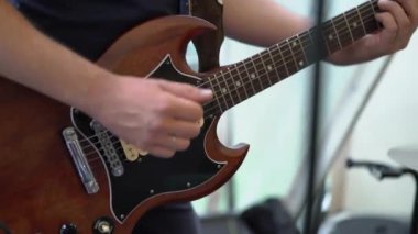 Gitarist, rock konserinde sahnede elektro gitar çalıyor..