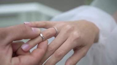 Gelin ve damat törende alyanslarını değiş tokuş ederler. Parmak mücevher yüzüğünü tak..