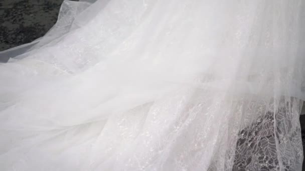 Nevěsta se jde projít. Vlak dlouhých bílých svatební šaty. — Stock video