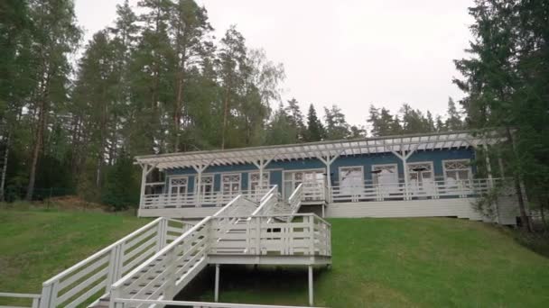 Drewniany budynek w stylu rustykalnym. Niebieski dom z białymi schodami na wzgórzu. — Wideo stockowe