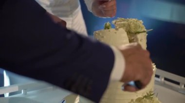 Düğün pastasından bir parça kesiyorum. Gelin ve damat resepsiyonda bıçakla.