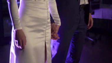 Gelin ve damat düğün töreninde el ele tutuşuyorlar. Aşık bir adam ve kadın