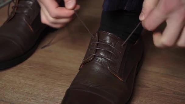 Facet wkłada buty. mężczyzna w szarym garniturze i skarpetki sznurowadła w jego buty. — Wideo stockowe