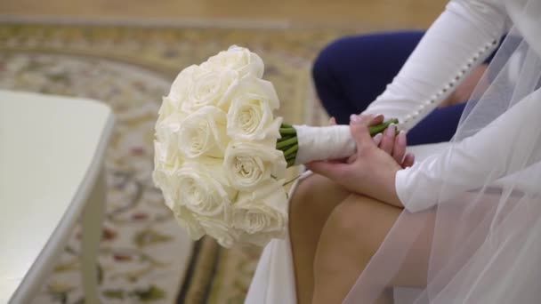 結婚式のドレスの花嫁は彼女の手に白い花の花束を持っています. — ストック動画