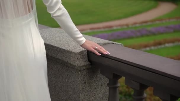 La mariée voilée va se promener. Train d'une longue robe de mariée blanche.