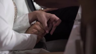 Gelin ve damat düğün töreninde el ele tutuşuyorlar. Aşık bir adam ve kadın