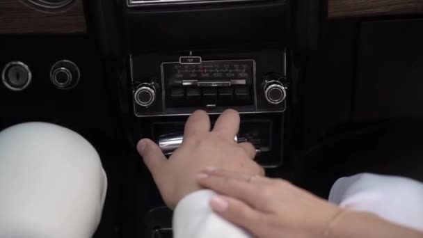Een verliefd stel in een auto die de hendel vasthoudt. Bruid en bruidegom. — Stockvideo