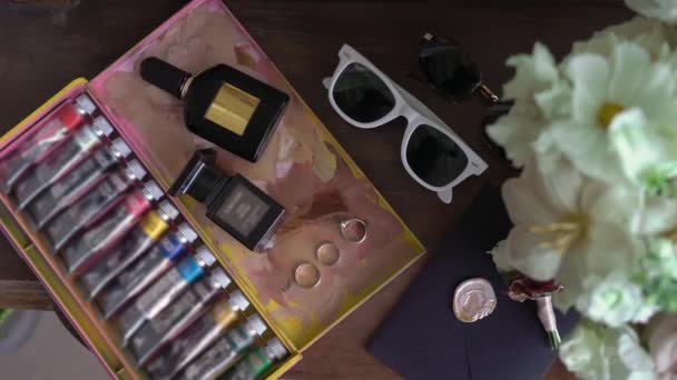 Свадебный букет из розовых цветов, колец, конверта, духов и солнцезащитных очков. — стоковое видео