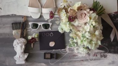 Beyaz gül çiçekleri, yüzükler, parfüm, ayakkabılar ve güneş gözlükleri..