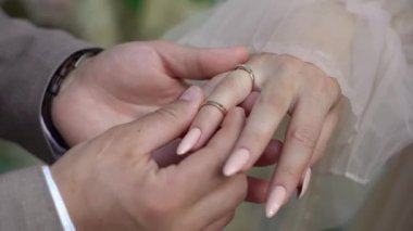 Gelin ve damat törende alyanslarını değiş tokuş ederler. Parmak mücevher yüzüğünü tak..
