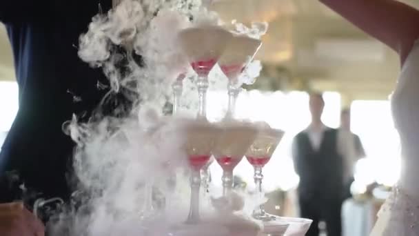 Bride and groom pour white sparkling wine into the tower from glasses. — 图库视频影像