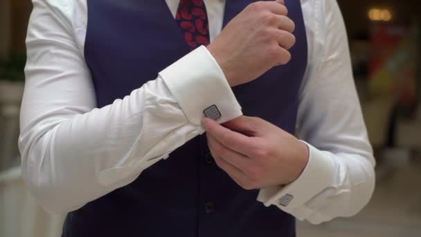 Ο άνθρωπος βάζει μανικετόκουμπα. Άνδρας με λευκό πουκάμισο, κόκκινη γραβάτα και γιλέκο με μπλε κοστούμι. — Αρχείο Βίντεο