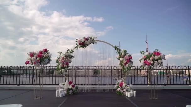 Dekorative Hochzeitszeremonie draußen. Bogen mit weißen und rosa Rosenblüten. — Stockvideo