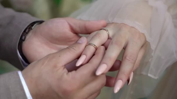 Brud- och brudgummen byter vigselringar vid ceremonin. Sätt på fingret smycken ring. — Stockvideo