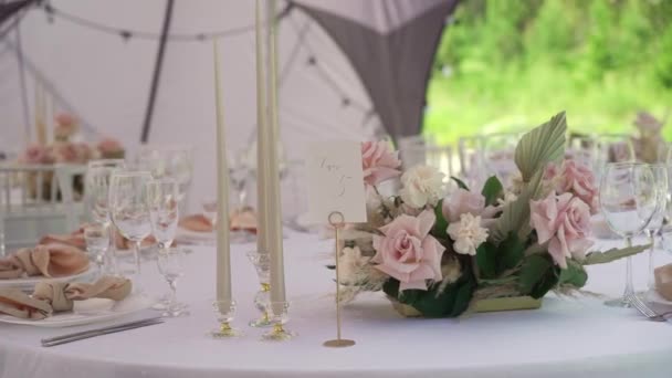 Serviert Tisch in einem Restaurant für Abendessen, Mittagessen oder Feier. Geschmückte Blumen — Stockvideo
