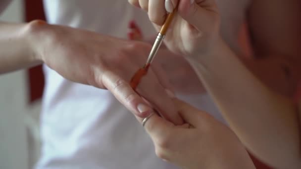 Jongeman maakt een huwelijksaanzoek aan een vrouw, schildert een symbolische trouwring. — Stockvideo