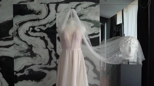 ชุดแต่งงาน ชุดเจ้าสาวสีขาว และผ้าคลุมแขวนบนไม้แขวนเสื้อในห้องนอน . — วีดีโอสต็อก