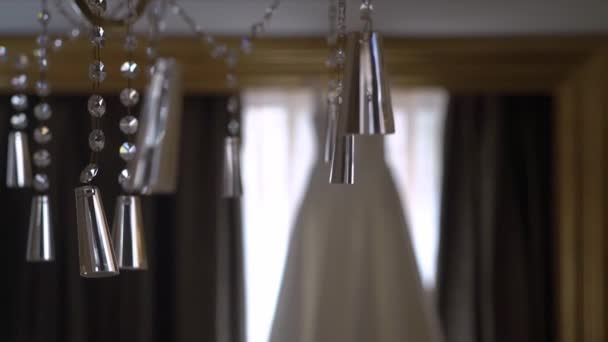 結婚式のドレスは窓のそばの寝室のハンガーにかかっている。花嫁の朝. — ストック動画