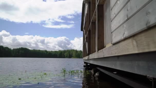 Holzhaus am Wasser. Gebäude auf einem Ponton in der Nähe eines Flusses oder Sees. — Stockvideo