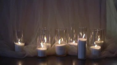 Şeffaf cam şişelerde fitilleri olan dekoratif beyaz mumlar..