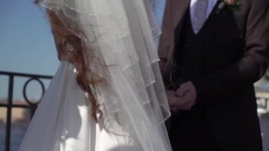 Gelin ve damat düğün töreninde el ele tutuşuyorlar..