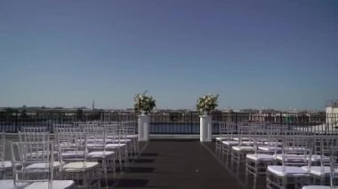 Dışarıda madalyalı bir düğün töreni. Beyaz ve pembe gül çiçekli kemer.