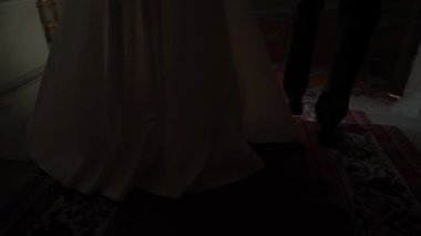 Gelin ve damat merdivenlerden iniyorlar. Düğün çifti el ele tutuşuyor..