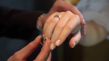 Gelin ve damat törende alyanslarını değiş tokuş ederler. Parmak mücevher yüzüğünü tak..
