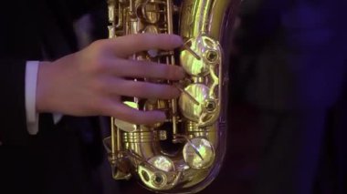 Saksafoncu içeride bir partide müzik çalar. Erkek müzisyen saksafon çalar.. 