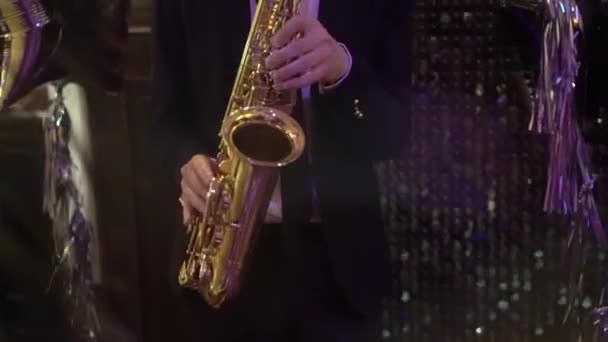 Saxofonist speelt muziek op een feestje binnen. Mannelijke muzikant speelt saxofoon. — Stockvideo