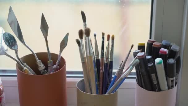 Sanatçılar bardakta fırçalar. Kalemler, keçeli kalemler atölyede.. — Stok video