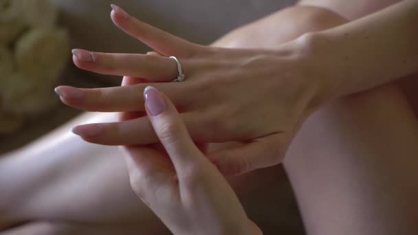 Nevěsta si nasazuje prsten na prst. Svatební prsten v bílém zlatě s diamantem na ruce. — Stock video