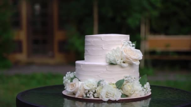 Bolo de férias branco decorado com flores de rosa. Sobremesa de casamento. — Vídeo de Stock