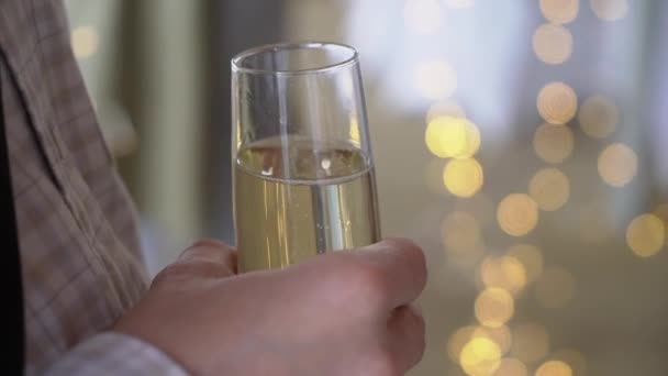 Человек с бокалом шампанского на вечеринке. Праздник, человек, пьющий алкогольные напитки, игристое вино. — стоковое видео