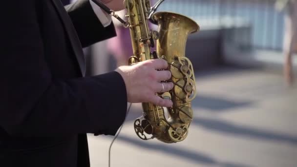 Il sassofonista suona musica ad una festa all'aperto. Musicista maschile suona il sassofono. — Video Stock
