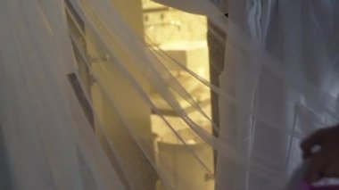 Kız elbiseyi buharlaştırıyor. Genç kadın ütü makinesi kullanıyor, giysileri ütülüyor..