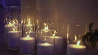 Şeffaf cam şişelerde fitilleri olan dekoratif beyaz mumlar..