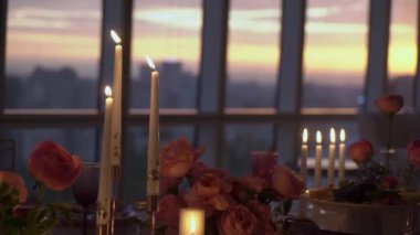 Restorandaki dekore edilmiş masa mumlar, pembe şakayık çiçekleri ve beyaz güllerle dolu..