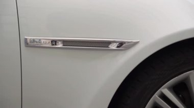 White luxury sedan Jaguar XJ long car parked in a city street.