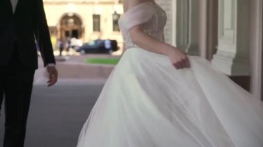 Uzun beyaz bir gelinlik içinde gelinlik rüzgarda uçuşuyor..