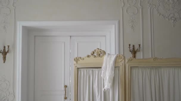 Person changes clothes behind a screen in the palace. The woman takes a white dress. — Video Stock