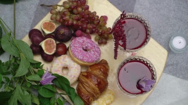 Outdoor picnic in the rain. Two glasses with red wine, mulled wine or juice. — Stockvideo