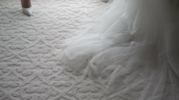Vestido de novia cuelga de una percha en el dormitorio junto a la ventana. Mañana de novia. — Vídeos de Stock