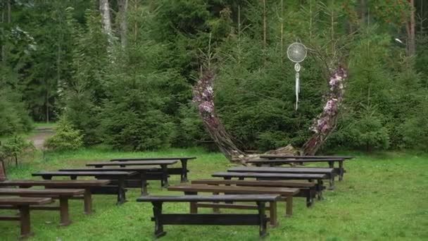 Decorated wedding ceremony outside. Wedding arch in forest at countryside. — Vídeo de stock