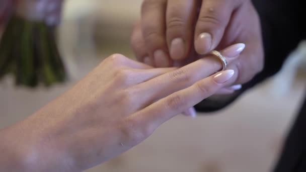 Brud- och brudgummen byter vigselringar vid ceremonin. Sätt på fingret smycken ring. — Stockvideo