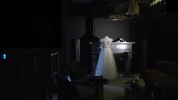 Wedding dress, white bridal gown and shoes on high heels hanging. Morning bride. — Video