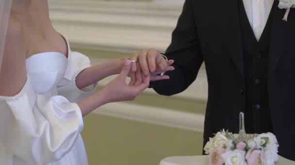 Oblubienica i pan młody wymieniają obrączki podczas ceremonii. Załóż pierścionek z biżuterią.. — Wideo stockowe