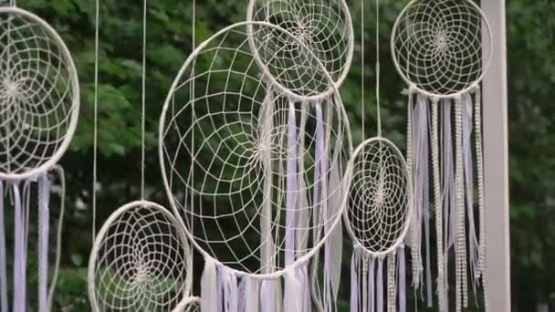 Dreamcatcher, white wicker dyed ribbons hang outside in the garden or backyard. — Vídeo de stock