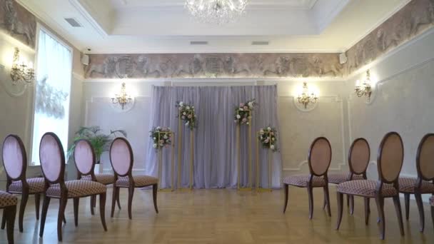 Ceremonia de boda decorada en interiores. Arco de boda decorado con flores de rosa. — Vídeo de stock