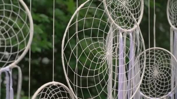 Dreamcatcher, white wicker dyed ribbons hang outside in the garden or backyard. — стоковое видео